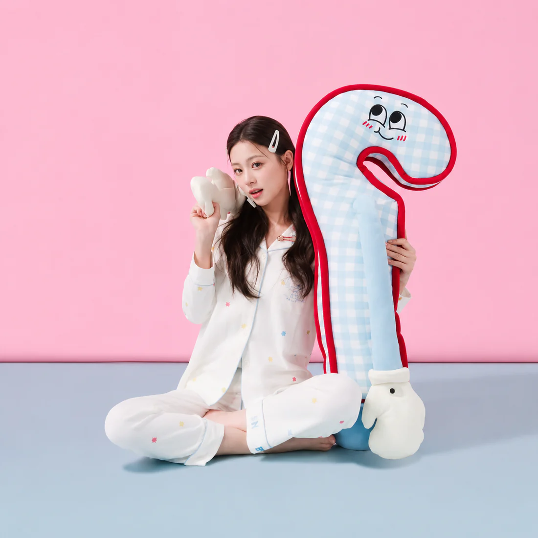 Person hugging a soft pink Hug Taps plushie in a cozy sweater